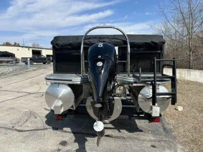 Slide: The Image of 2025 Lowe LS 230 pontoon boat with outboard motor, parked outdoors. - 5