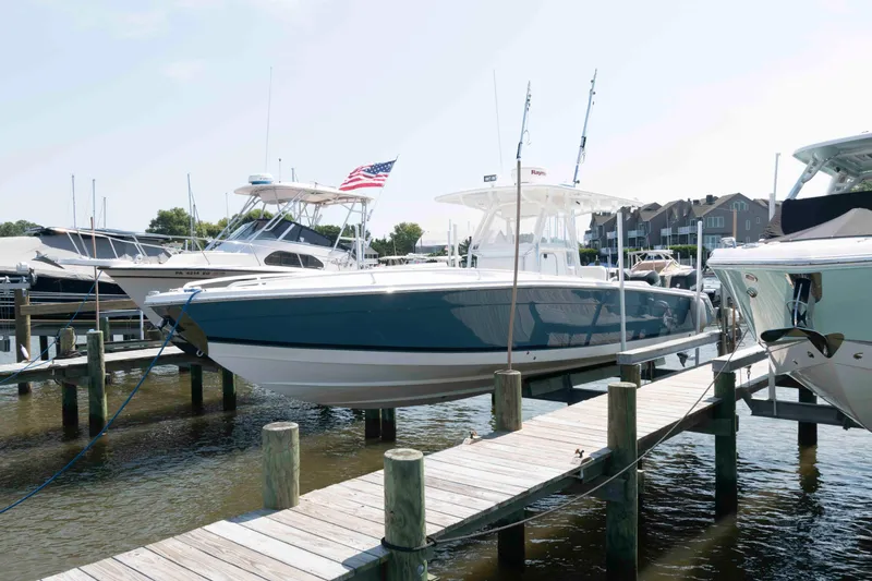 The Image of 2008 Marlago FS 35 Center Console Cuddy docked at marina with American flag. - 0