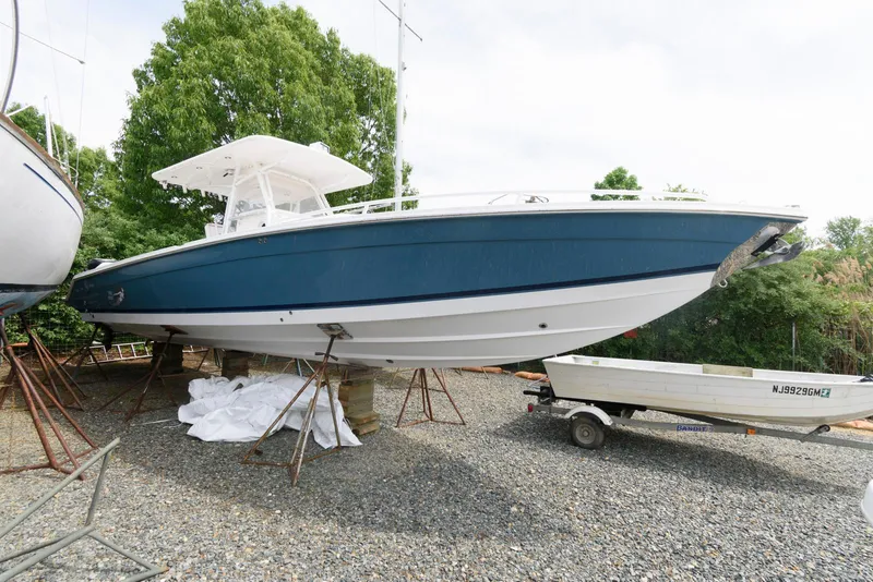 Slide: The Image of 2008 Marlago FS 35 Center Console Cuddy boat on stands, blue hull, outdoor setting. - 3