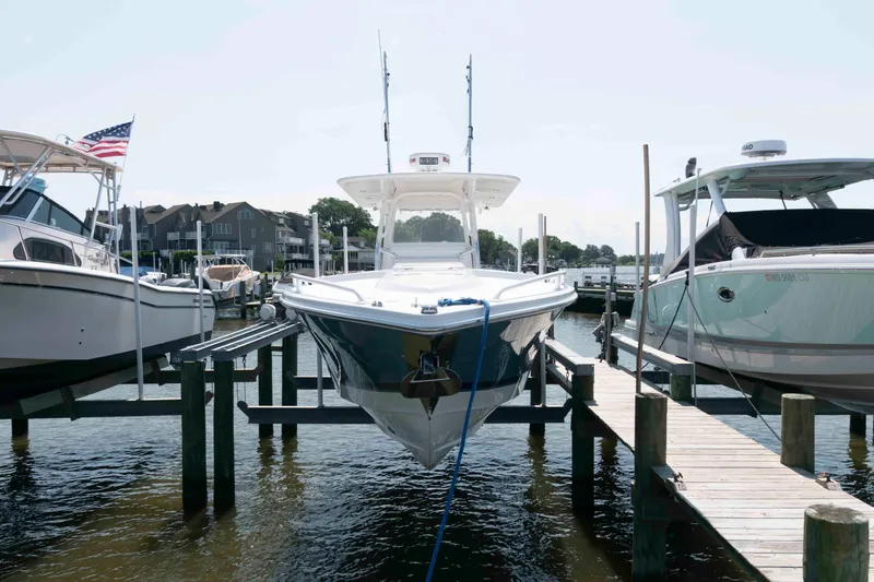 Slide: The Image of 2008 Marlago FS 35 Center Console Cuddy docked at marina, surrounded by other boats. - 4