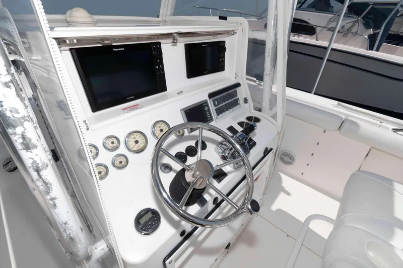 Slide: The Image of 2008 Marlago FS 35 Center Console Cuddy helm with steering wheel and navigation displays. - 7