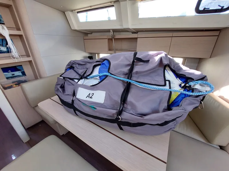 Slide: The Image of Interior of 2022 Beneteau Oceanis 46.1 with a large bag on the table. - 29