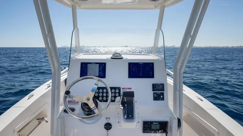 Slide: The Image of 2025 SeaWell 240CC boat dashboard with ocean view, featuring modern controls and steering wheel. - 15