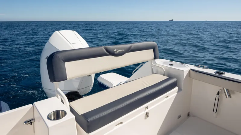 Slide: The Image of 2025 SeaWell 240CC boat with cushioned seating, ocean view, and outboard motor. - 28