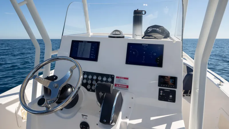 Slide: The Image of Control panel of 2025 SeaWell 240CC boat with steering wheel and digital displays. - 32