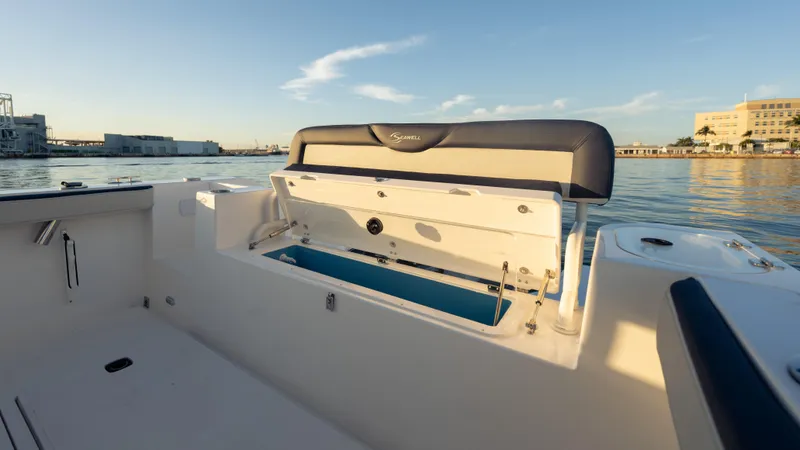 Slide: The Image of 2025 SeaWell 240CC boat interior with open storage compartment, docked by calm waters. - 36