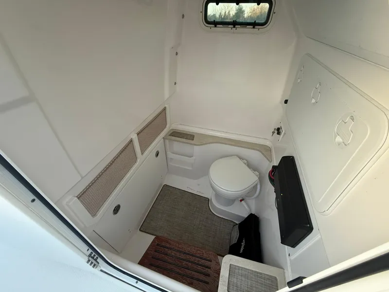 Slide: The Image of Interior of 2023 Everglades 273 Center Console boat bathroom with toilet and window. - 19