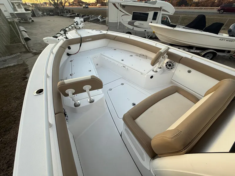 Slide: The Image of 2023 Everglades 273 Center Console boat interior with beige seating and white deck. - 21