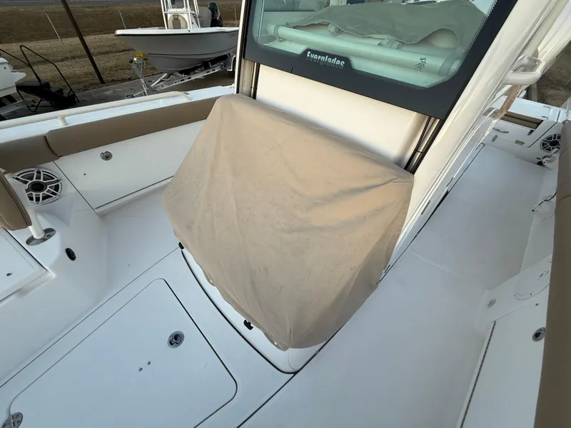 Slide: The Image of 2023 Everglades 273 Center Console boat interior with covered console and seating area. - 28