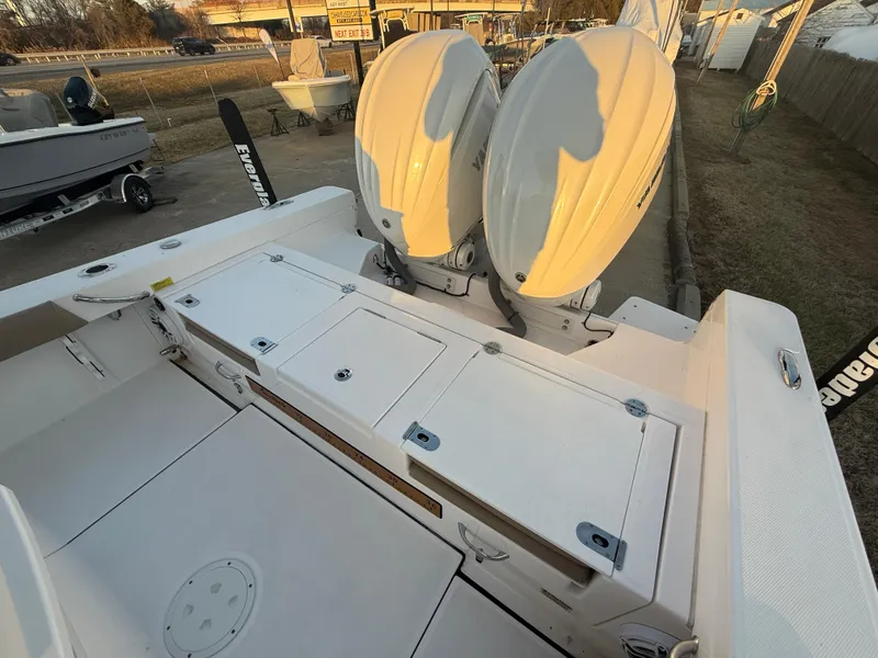 Slide: The Image of 2023 Everglades 273 Center Console boat with dual engines, docked outdoors. - 7