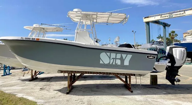 Slide: The Image of 2021 Dusky 252 T boat on dry dock with "Sky" logo, sunny day. - 11