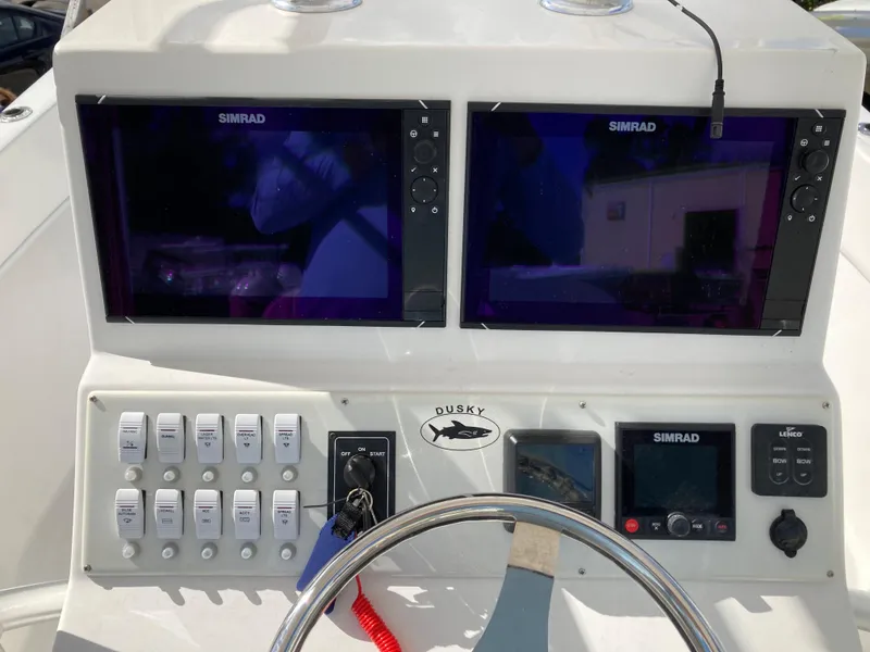 Slide: The Image of Control panel of 2021 Dusky 252 T boat with Simrad displays and switches. - 16