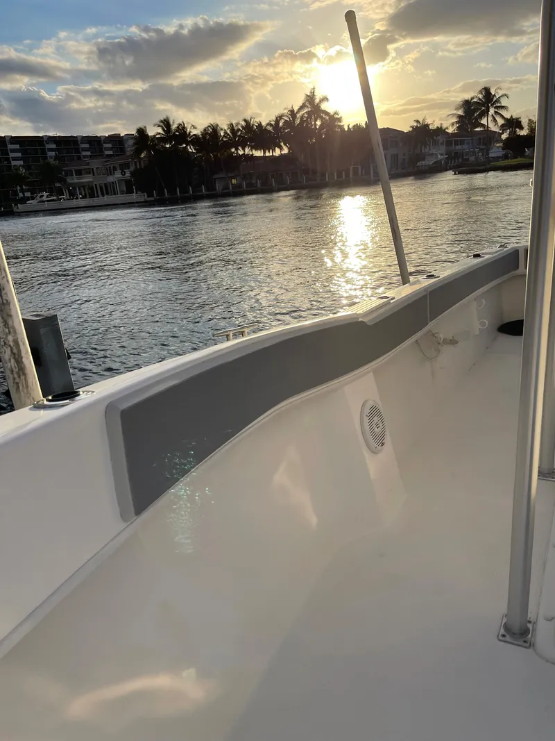 Slide: The Image of Dusky 252 T boat, 2021 model, on calm water at sunset with scenic view. - 26
