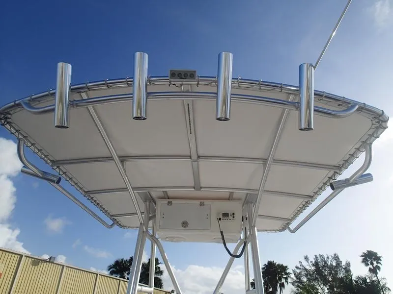 Slide: The Image of 2021 Dusky 252 T boat T-top with rod holders against a clear blue sky. - 31