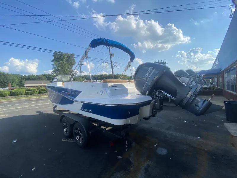 Slide: The Image of 2023 Glastron GTD 220 boat with Yamaha outboard motor, parked outdoors under a blue sky. - 10