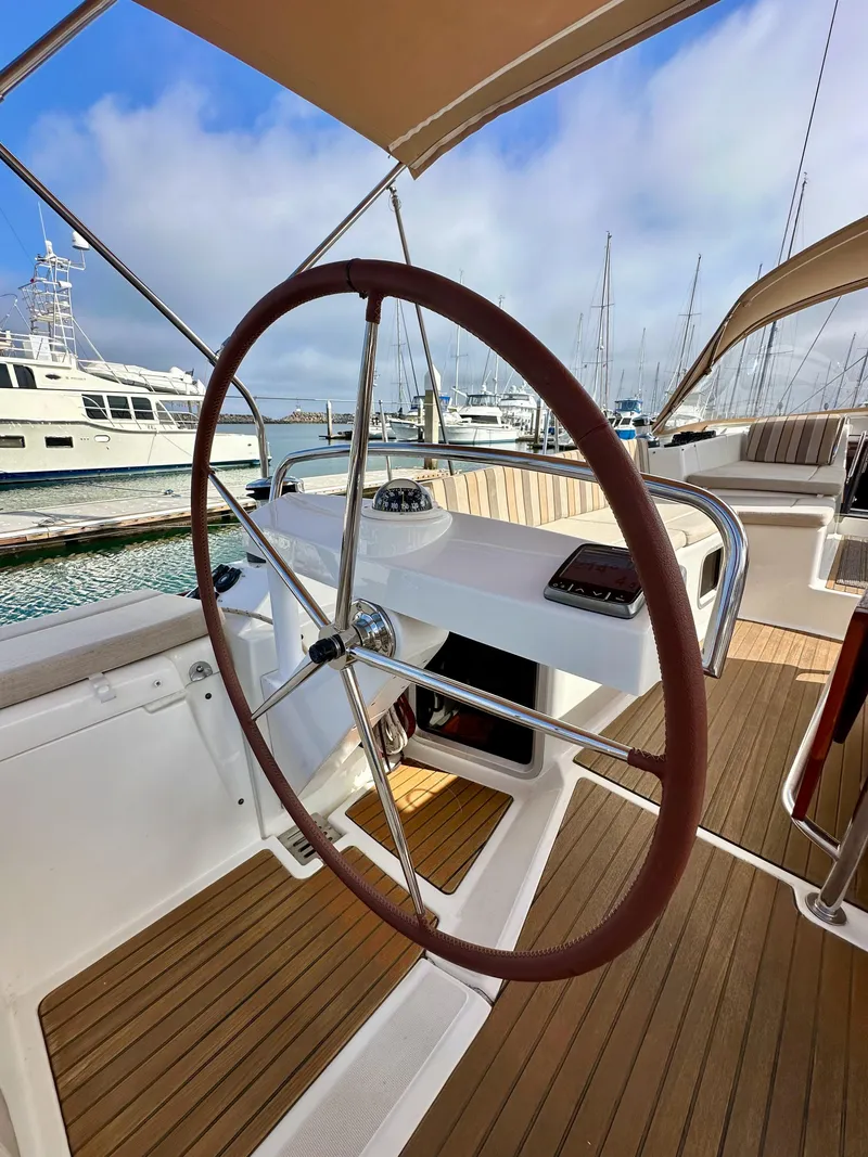 Slide: The Image of 2014 Jeanneau 57 yacht helm with wooden deck, docked at marina. - 26