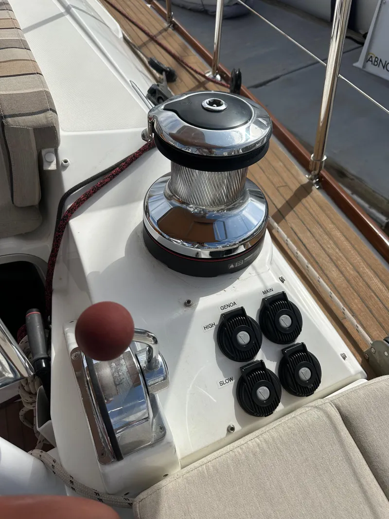 Slide: The Image of Jeanneau 57 sailboat deck controls and winch, 2014 model, featuring polished chrome and wood accents. - 35