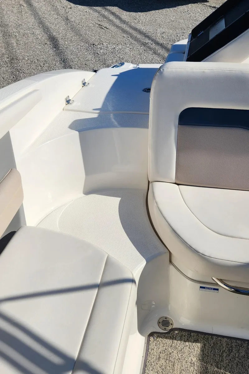 Slide: The Image of 2015 Chaparral 226 SSi boat interior with white seating and textured flooring. - 15