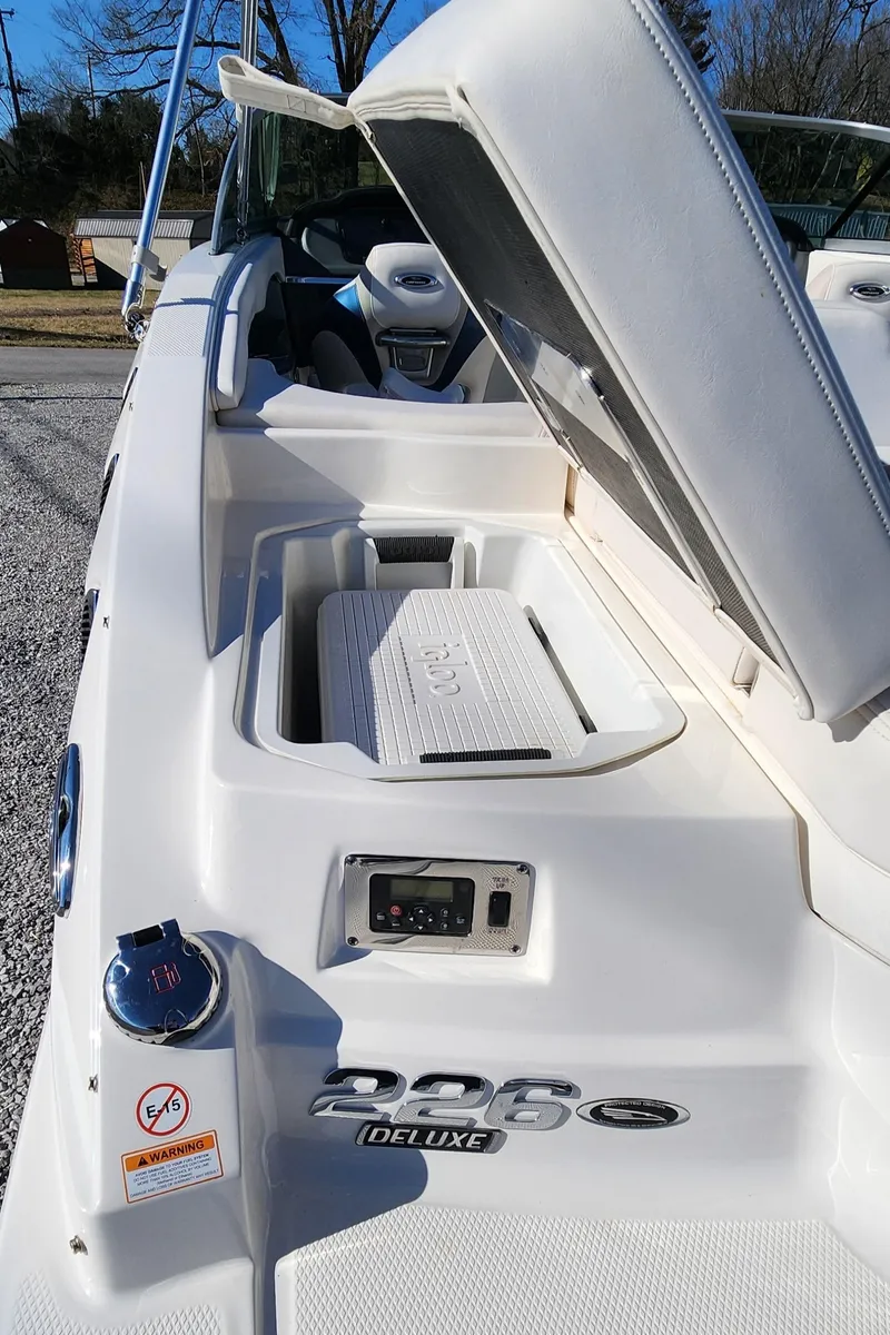 Slide: The Image of 2015 Chaparral 226 SSi boat with open storage compartment and visible deluxe features. - 17