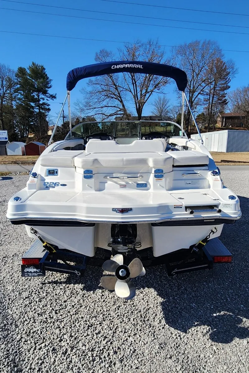 Slide: The Image of 2015 Chaparral 226 SSi boat, rear view, on gravel, with blue canopy. - 4