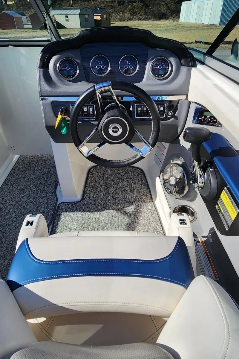 Slide: The Image of 2015 Chaparral 226 SSi boat cockpit with steering wheel and dashboard controls. - 9
