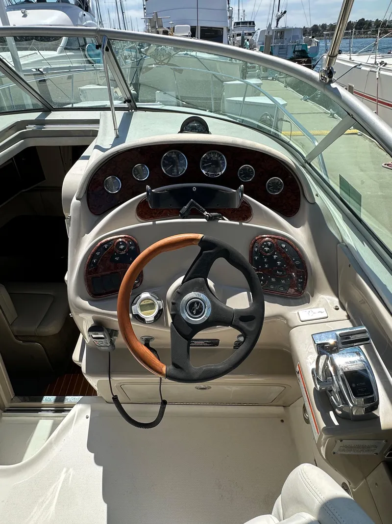 Slide: The Image of 2009 Sea Ray 280 Sundancer cockpit with steering wheel and control panel. - 14
