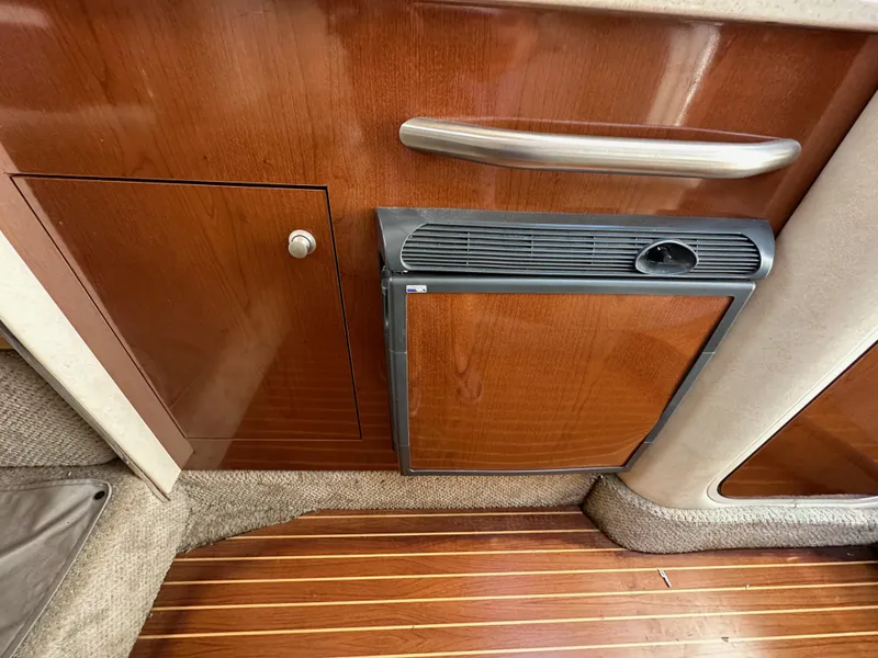 Slide: The Image of 2009 Sea Ray 280 Sundancer interior with wood cabinetry and compact refrigerator. - 24