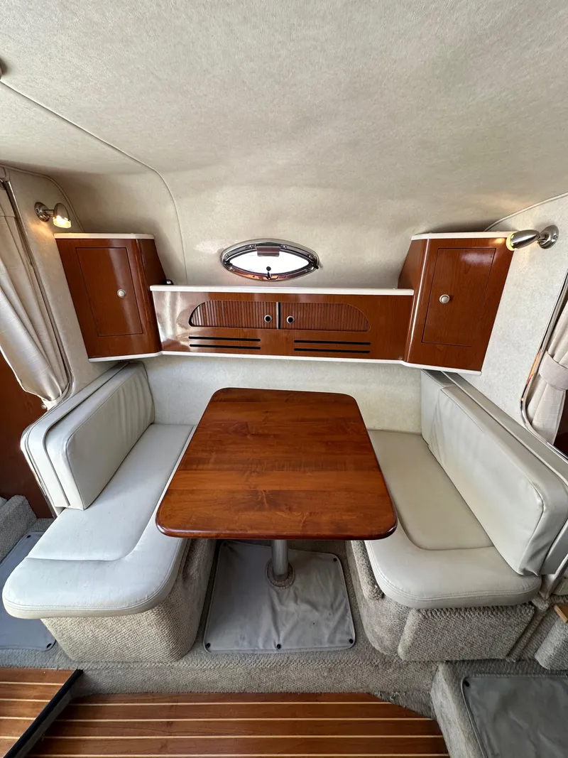 Slide: The Image of Interior of a 2009 Sea Ray 280 Sundancer with a cozy dining area and wooden table. - 25