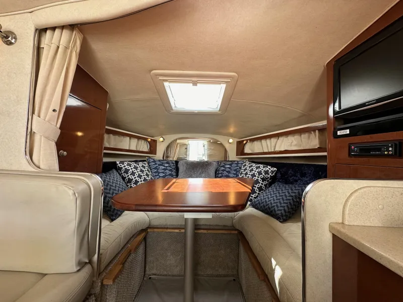 Slide: The Image of Interior of 2009 Sea Ray 280 Sundancer with cozy seating and wooden table. - 26