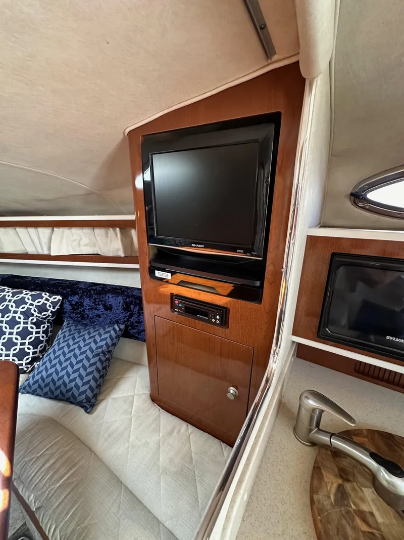 Slide: The Image of Interior of 2009 Sea Ray 280 Sundancer with TV, wood paneling, and cozy seating area. - 27