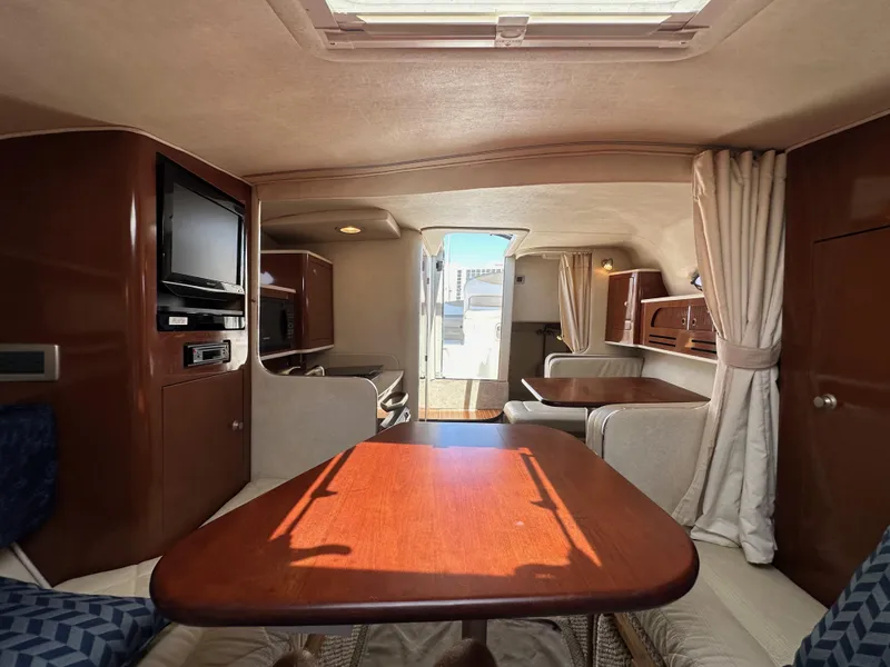 Slide: The Image of Interior of 2009 Sea Ray 280 Sundancer, featuring cozy seating and wooden table. - 28