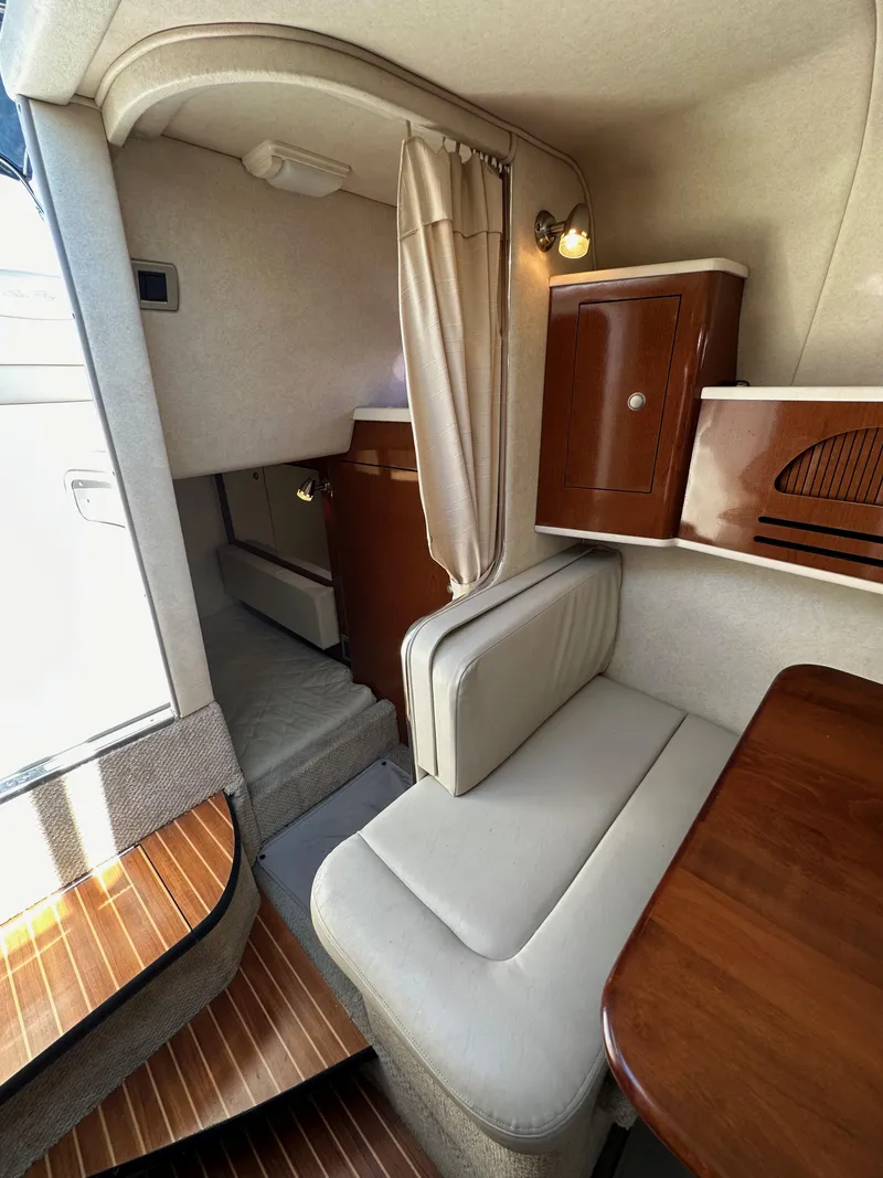 Slide: The Image of Interior of 2009 Sea Ray 280 Sundancer with seating, table, and cabinetry. - 29
