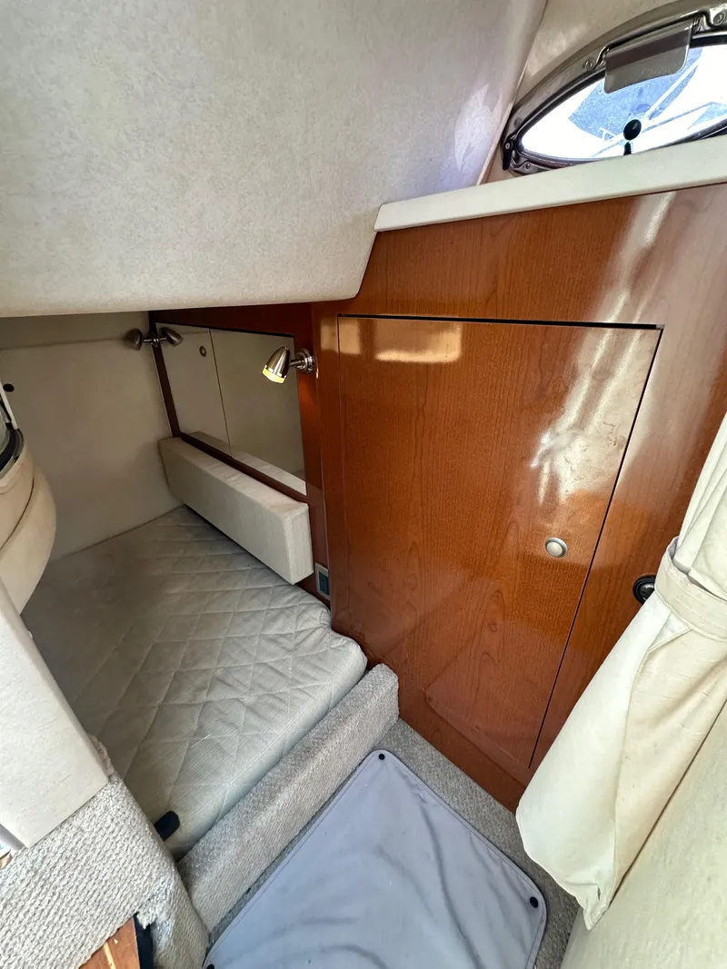 Slide: The Image of 2009 Sea Ray 280 Sundancer cabin interior with wood paneling and compact sleeping area. - 30