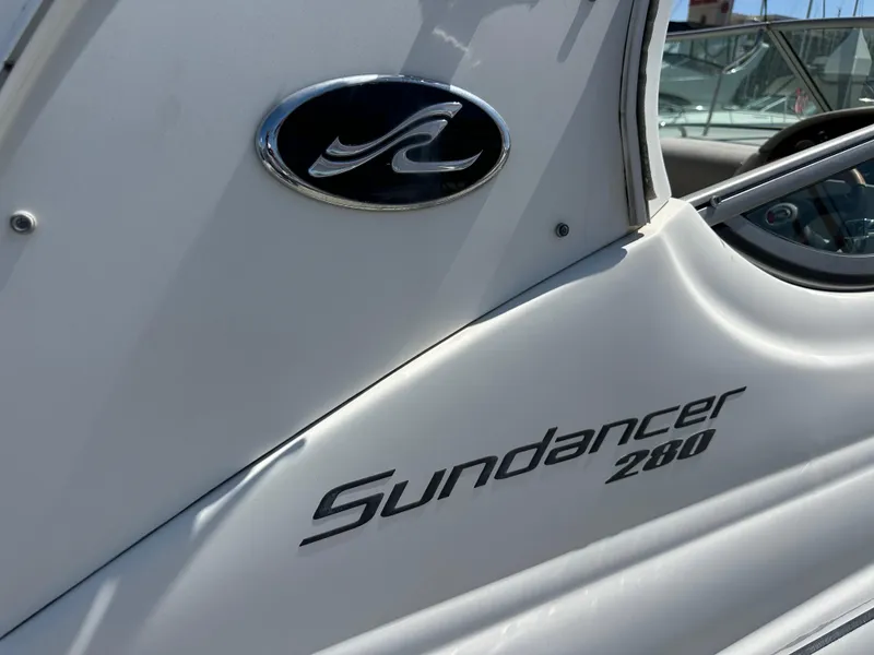 Slide: The Image of 2009 Sea Ray 280 Sundancer boat logo and model name on white hull. - 40