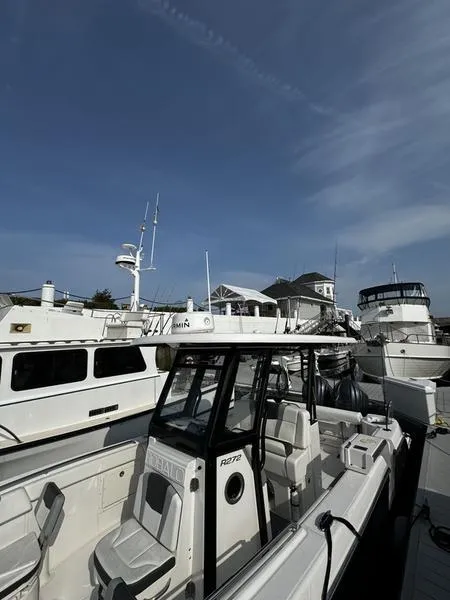 Slide: The Image of 2022 Robalo R272 boat docked among other vessels under a clear blue sky. - 3