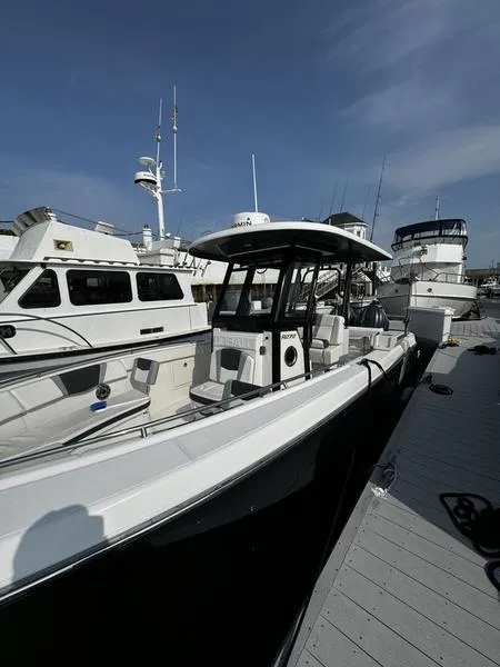 Slide: The Image of 2022 Robalo R272 boat docked at marina under clear blue sky. - 4