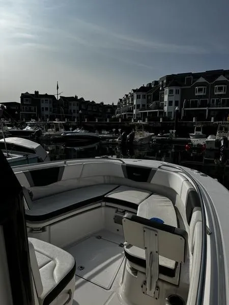 Slide: The Image of 2022 Robalo R272 boat docked in a marina with waterfront buildings in the background. - 9