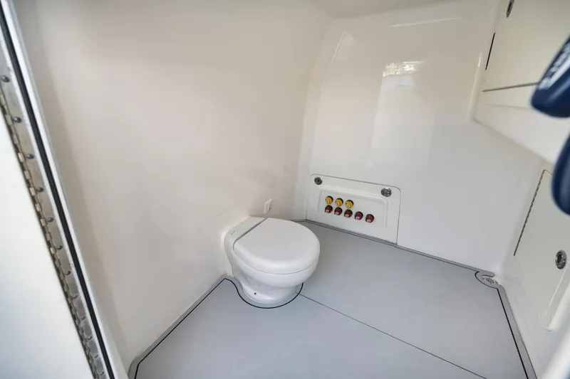 Slide: The Image of Interior of 2018 Invincible 40 Catamaran bathroom, featuring a compact toilet and control panel. - 19