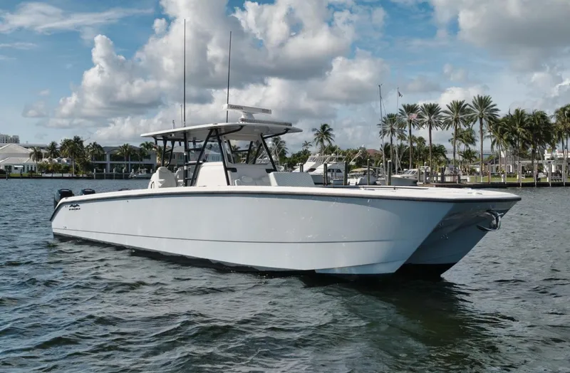 Slide: The Image of 2018 Invincible 40 Catamaran on water, clear sky, palm trees in background. - 25