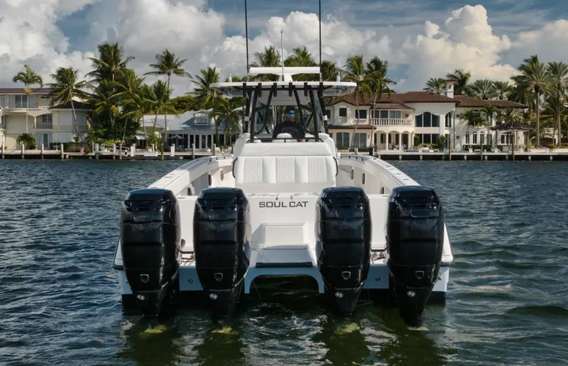 Slide: The Image of 2018 Invincible 40 Catamaran with four engines, docked near waterfront homes. - 26