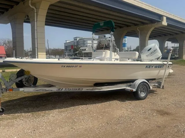Slide: The Image of 2004 Key West 196 Bay Reef boat on trailer under bridge. - 2