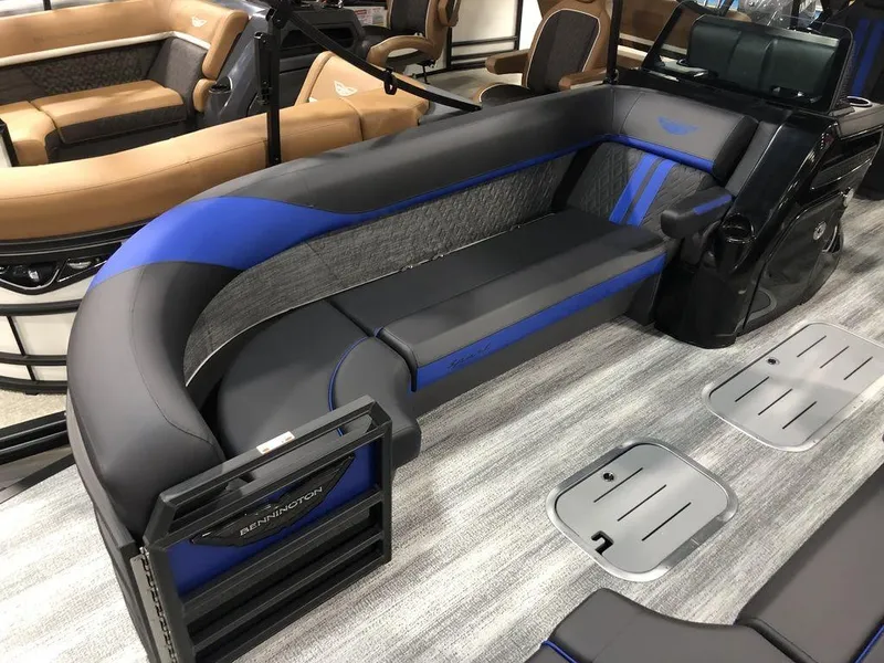 Slide: The Image of 2025 Bennington M Quad Bench 24 MFB with sleek gray and blue seating on a boat. - 6