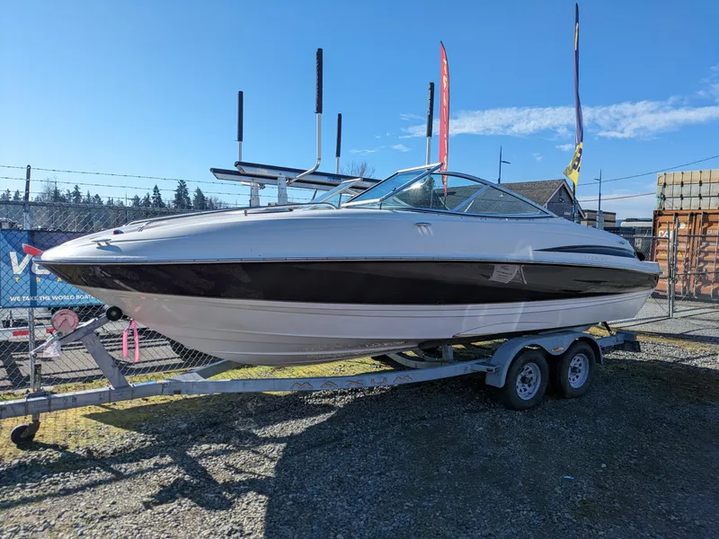 Slide: The Image of 2002 Maxum 2100 SC boat on trailer, displayed outdoors under clear blue sky. - 0