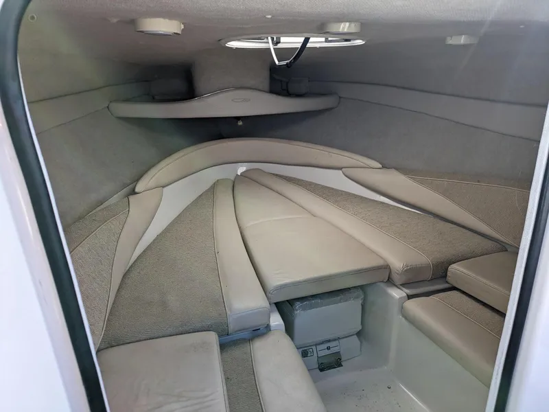 Slide: The Image of 2002 Maxum 2100 SC boat interior cabin with cushioned seating and storage. - 10