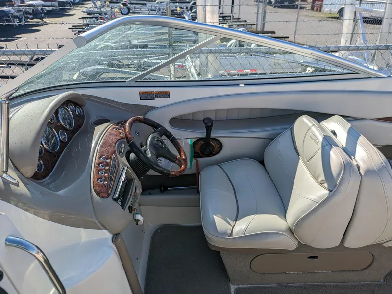 Slide: The Image of 2002 Maxum 2100 SC boat interior with steering wheel and dashboard controls. - 16