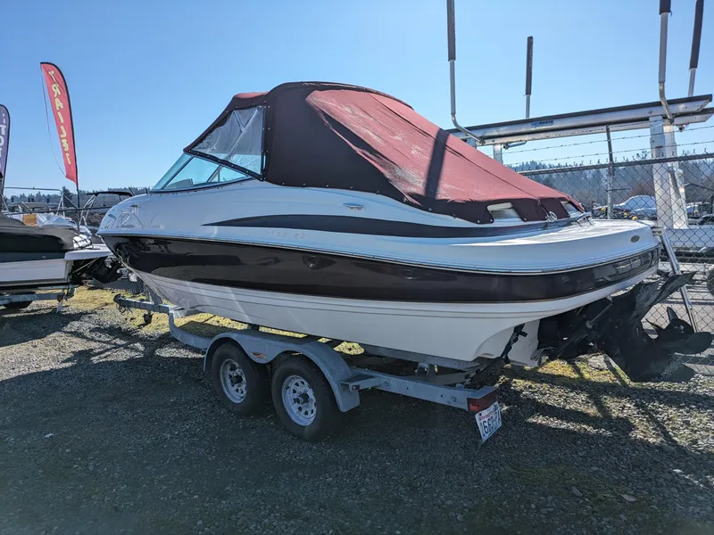 Slide: The Image of 2002 Maxum 2100 SC boat on trailer with maroon cover, parked outdoors. - 2