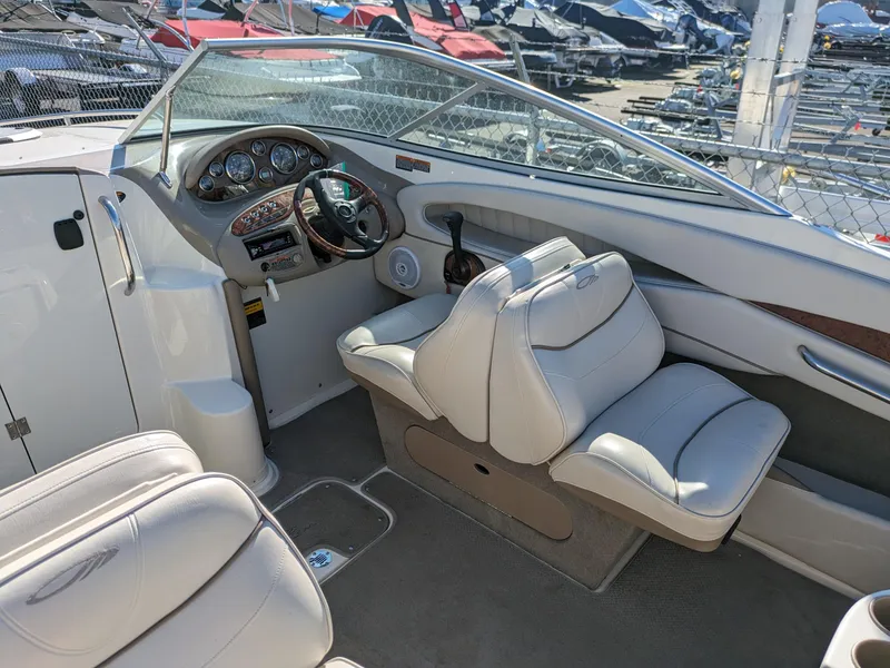 Slide: The Image of 2002 Maxum 2100 SC boat interior with white seating and dashboard controls. - 6