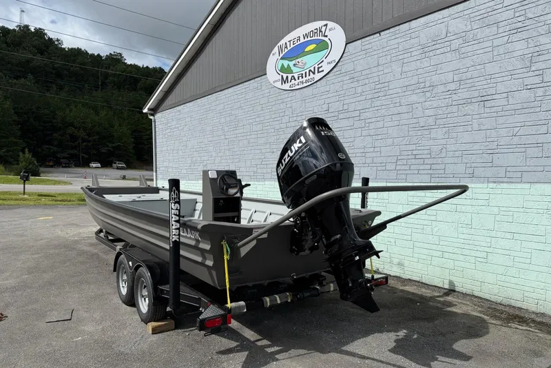 Slide: The Image of 2025 SeaArk 2472 Workhorse 240 boat on trailer, parked outside Water Workz Marine. - 2