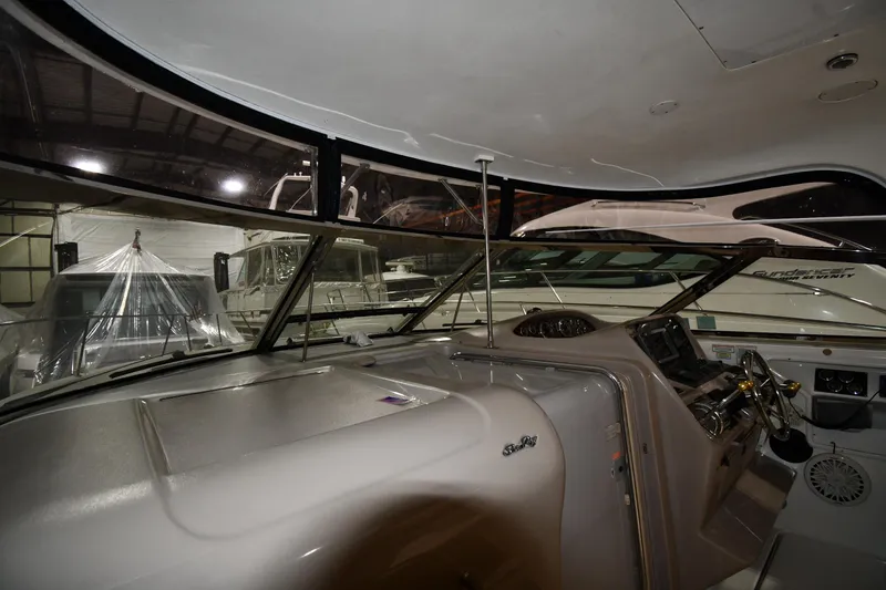 Slide: The Image of 2000 Sea Ray 370 Express Cruiser cockpit with steering wheel and dashboard in a storage facility. - 10