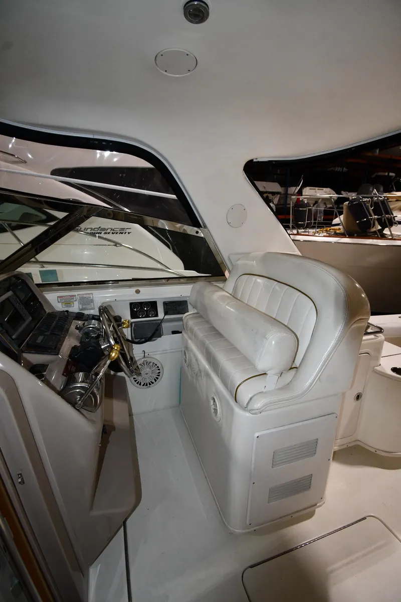 Slide: The Image of 2000 Sea Ray 370 Express Cruiser helm with white seating and control panel. - 17